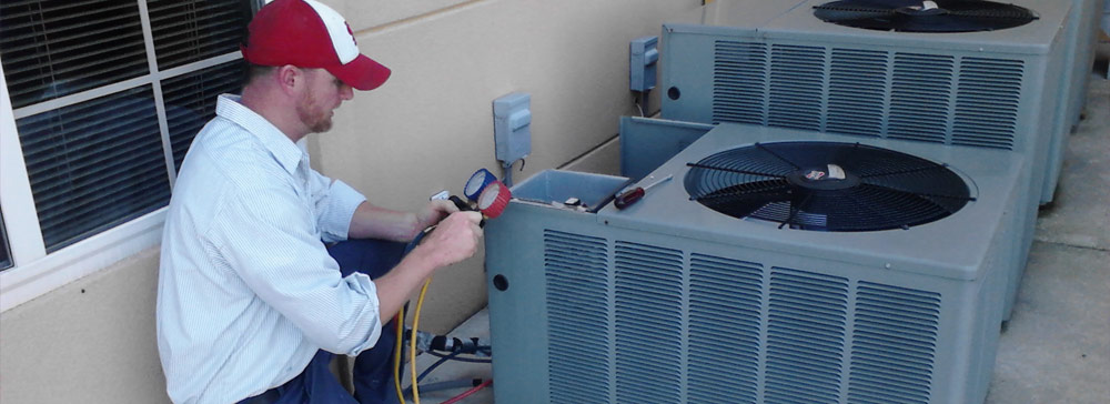 Weir Heating & Cooling maintenance worker repairing and outdoor air conditioning unit in Cahokia, IL