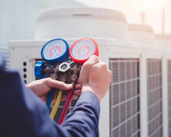 HVAC technician with heating and cool temperature gauge | Heating and Cooling Services for the Missouri and Illinois Bi-State Area by Weir Heating and Cooling in Cahokia, IL